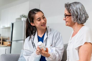 Asian caregiver nurse give consult to Caucasian senior woman patient.