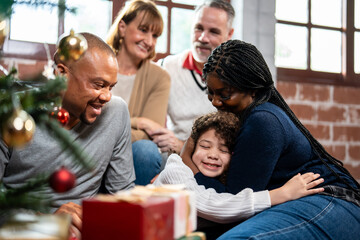 Multi-ethnic family exchanging presents during Christmas party at home. 