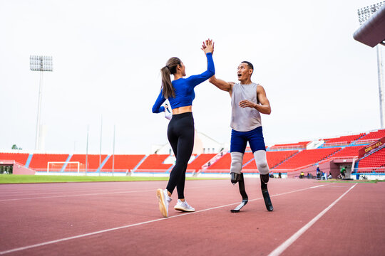 Asian athlete with prosthetic blades and trainer workout in stadium. - Powered by Adobe