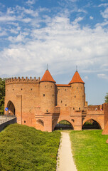 Fototapeta na wymiar Historic red brick city gate in the center of Warsaw, Poland