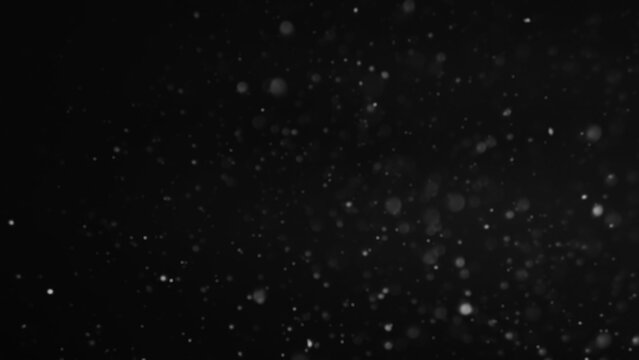 Winter night. Defocused snowflakes. Abstract illustration of snowfall glowing surface in powdery black sky flying flakes on dark copy space background.