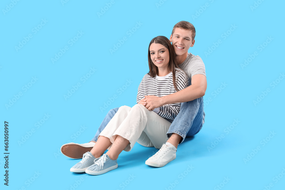 Sticker Happy young couple hugging on blue background