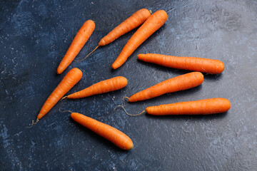 Many fresh carrots on blue background