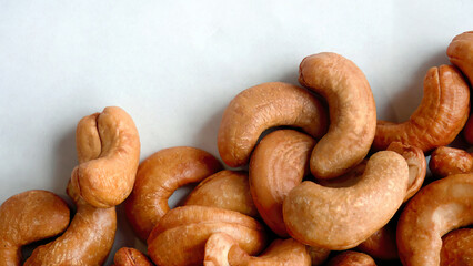 Top view pile heap of Roasted Cashew nuts isolated on white background, healthy vegetarian snack food, flat lay with copy space