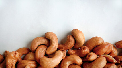 Top view pile heap of Roasted Cashew nuts isolated on white background, healthy vegetarian snack food, flat lay with copy space