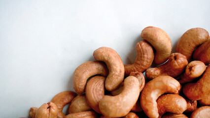 Top view pile heap of Roasted Cashew nuts isolated on white background, healthy vegetarian snack food, flat lay with copy space