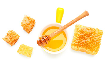 Bowl of sweet honey, dipper and combs on white background