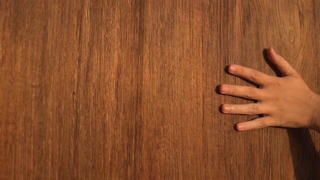 Close-up of a woman's hand touching a wooden wall surface 4K