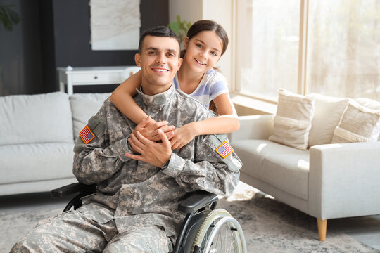 Soldier in wheelchair with his little daughter at home. Veterans Day celebration - Powered by Adobe