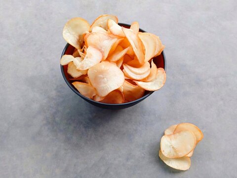 Cassava chips served in a bowl. Traditional snack made from thinly sliced ​​cassava and then fried. snacks to accompany your time relaxing or watching TV shows. Keripik singkong