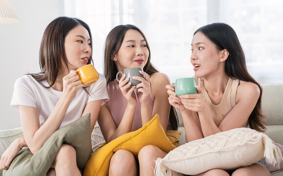 Portrait of young beautiful asian woman group hands holding coffee cup gossip morning time in living room Happy cheerful relax in summer. Korean asian makeup wakeup university asia together lifestyle