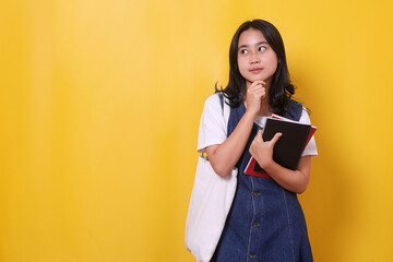 Young student woman having doubts thinking and looking away on yellow background