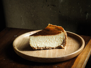 piece of caramelized New York cheesecake on wooden board