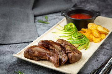 beef meat with chips, cucumbers and barbecue sauce, side view
