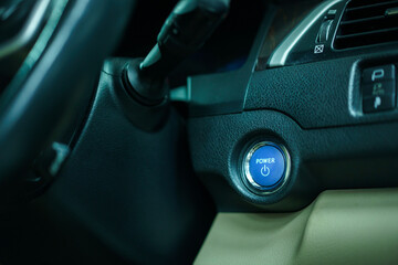 Close up of engine start button in the modern electric vehicle or EV. Car engine start button in blue color close up.