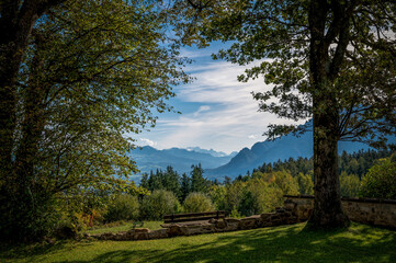 Blick in die Alpen im Herbst, B&uuml;me und Wiese mit Bank im Vordergrund