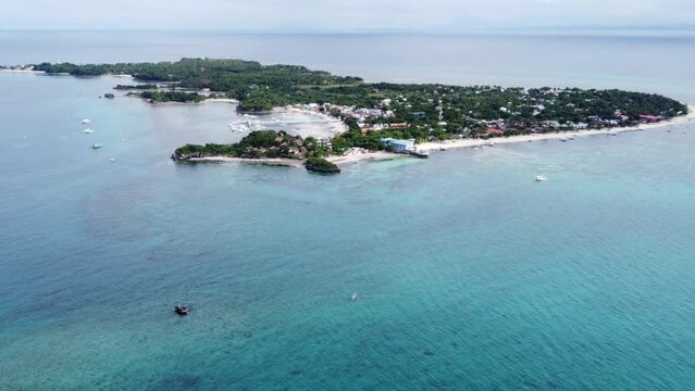 Malapascua island far away in the distance in an aerial dolly out long shot, Philippines.