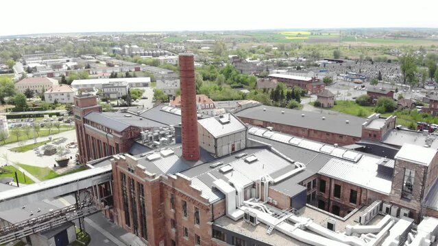 large, brick building with a chimney - Arche Hotel Żnin inside old sugar factory in Poland. Aerial drone shot.