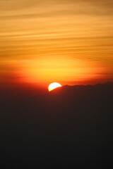 Half-Sunrise Majesty: Bromo's Half-Visible Sun in Vertical Splendor