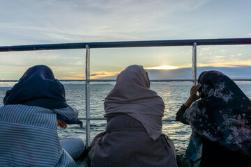 Traveling concept. asian hijab girls travels on ship. Looking at the beautiful view of the ocean.