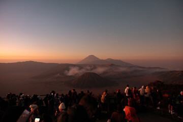 Fototapeta premium Crowded Awe: Bromo's Sunrise Embraces Enthralled Crowd