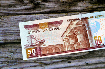 Reverse sides of 50 LE fifty Egyptian pounds banknote series 2001 features an image of temple of Edfu, winged scarab and a pharaonic boat, selective focus of Egyptian money bill, old vintage retro - obrazy, fototapety, plakaty