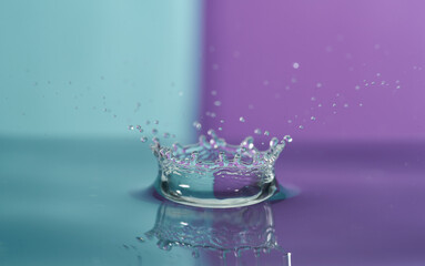 Group of colorful water droplets fall and bounce on a water surface