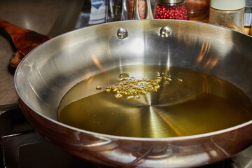 Olive oil in frying pan with chia grains - obrazy, fototapety, plakaty