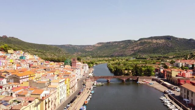Establishing aerial view of river Temo and colorful Bosa townscape, dolly in
