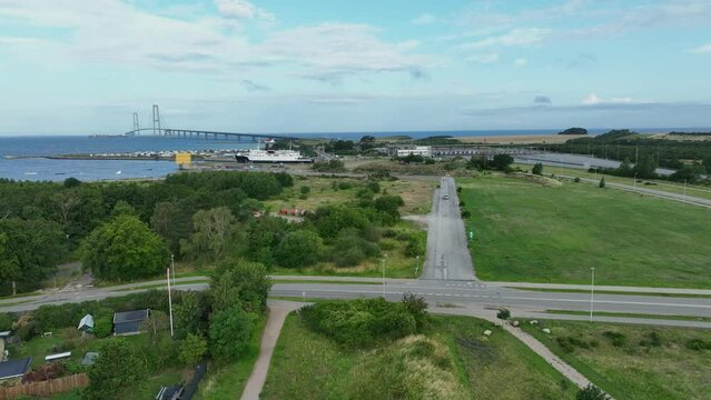 The Great Belt bridge in Denmark seen from Korsor - Aerial showing old belt strait ferry and toll checkpoint with bridge in background horizon