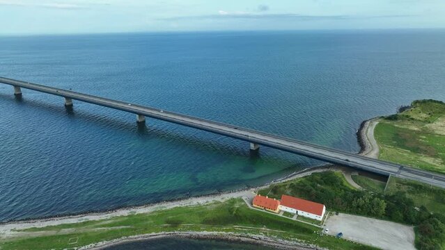 Great Belt bridge Crossing strait between Funen and Zealand in Denmark - Stunning aerial following cars at bridge entrance before revealing full panoramic view of bridge