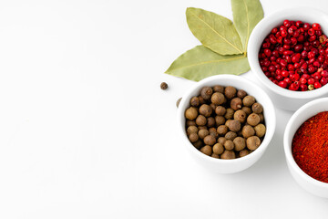 Various spices in a bowls on white background