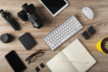 top view of photographer workstation, workspace concept with digital camera, laptop, memory card, smartphone and external hard drive. - obrazy, fototapety, plakaty