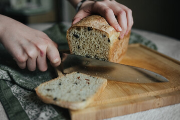 hand with a knife, woman cuts bread with a knife
