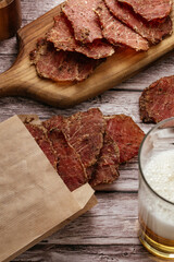 Snack for Beer. Grilled pork jerky on wood table