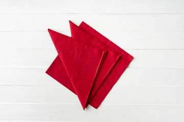 Red paper napkins on white wooden background