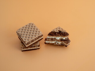 Delicious chocolate waffles with hazelnuts on an orange background. Wafers with chocolate and nuts.