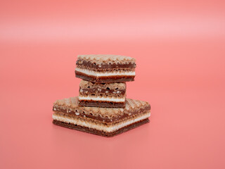 Delicious chocolate wafers with hazelnuts on a pink background. Wafers with chocolate and nuts.