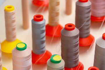 Row of multicolored thread spools at sewing factory