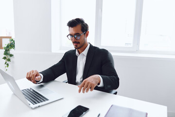 Man in office businessman sitting at desk and working in laptop, finance and startup concept, working lifestyle in bright office.