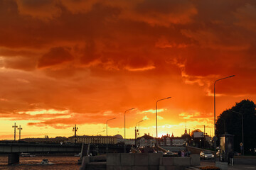 The city at sunset is flooded with bloody light from the setting sun. Dramatic sky over European city.