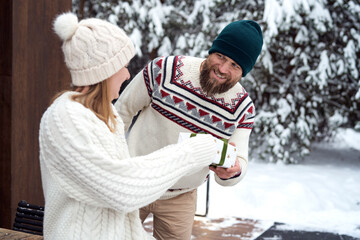 Caucasian couple sharing the Christmas present outdoors