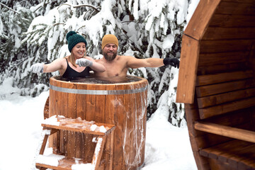 Caucasian couple enjoying the winter bath in tube outdoors
