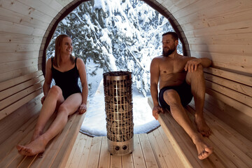 Caucasian adult couple enjoying in the sauna in winter