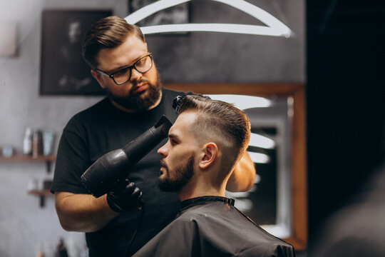 Handsome man at a barber shop styling hair