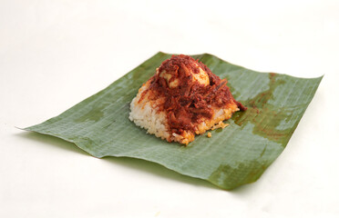 nasi lemak, a traditional malay curry paste rice dish served on a banana leaf, isoalted on white background