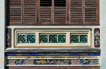 Ancient house with traditional decorative in George Town. Heritage Chinese porcelain decor house in penang. Vintage wooden louvred shutters.