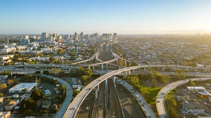  A drone view over the freeway cypress in Oakland, California during sunset with the downtown in the background. © Rich