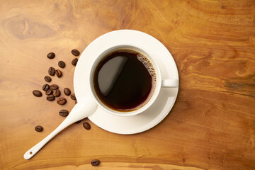 Black coffee and coffee beans on Wooden table