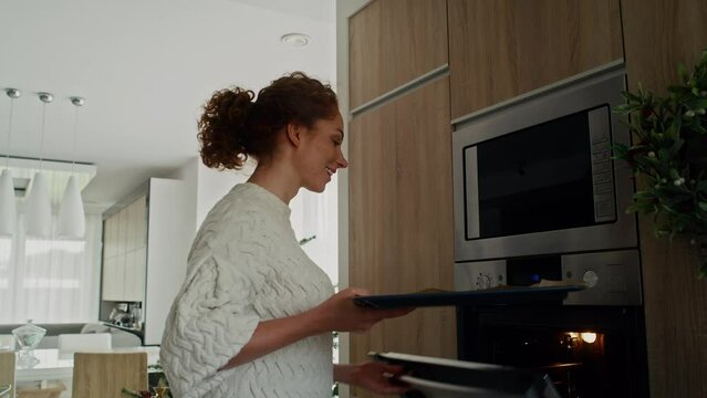 Caucasian woman baking gingerbread cookies for Christmas in the oven. Shot with RED helium camera in 8K. 